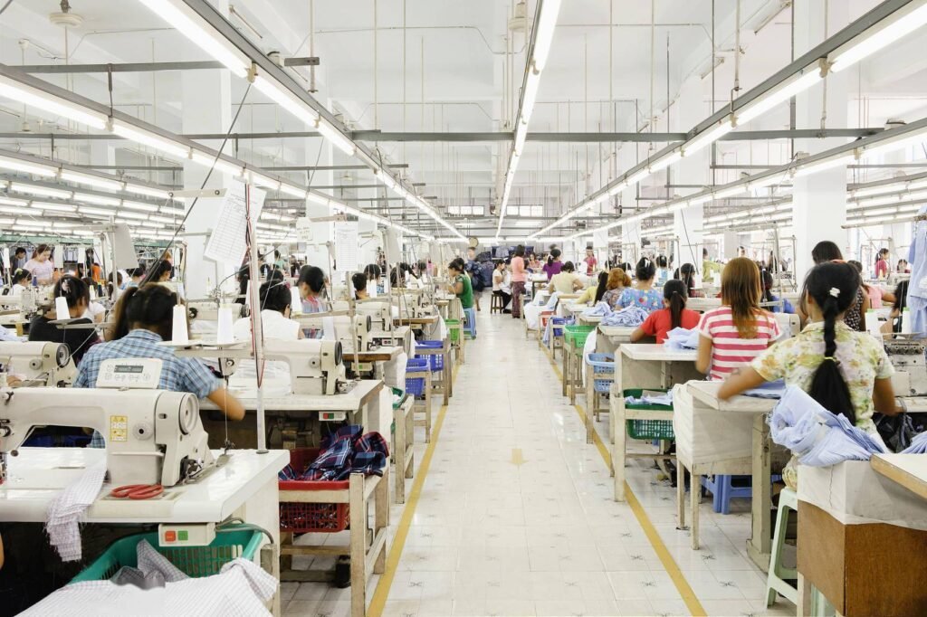 custom clothing factory production floor, seamstresses sewing bespoke apparel for wholesale orders
