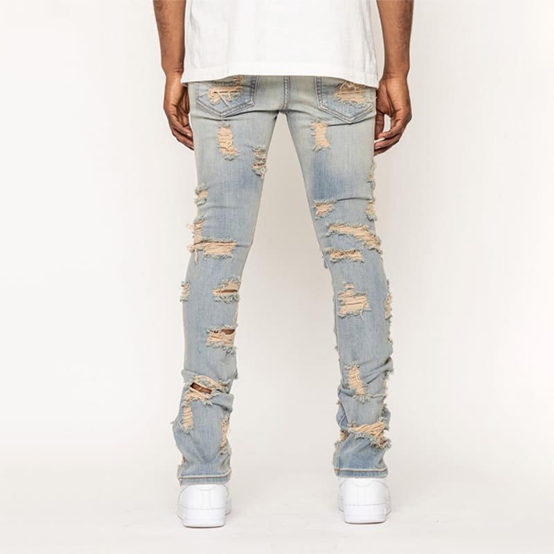 full back view denim trousers, scattered frayed rip detailing across sand-toned woven textile