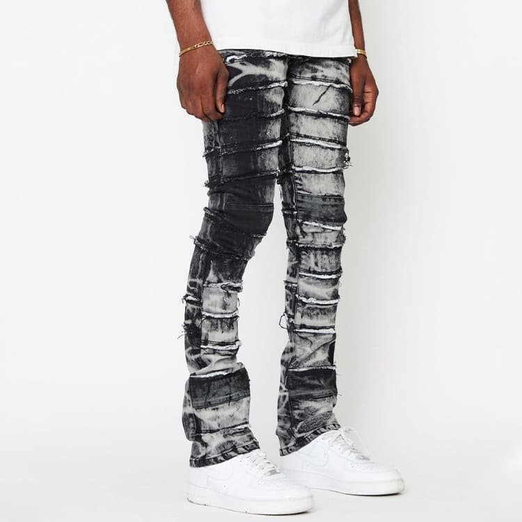 side profile of custom stretch denim trousers, raw edge fray texture and gradient black grey pigment wash pattern